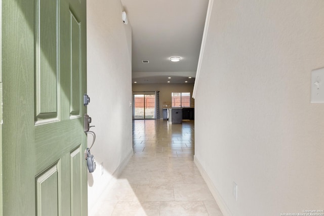 hallway with baseboards and light tile patterned floors