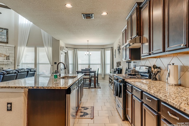 kitchen featuring under cabinet range hood, a sink, visible vents, appliances with stainless steel finishes, and an island with sink