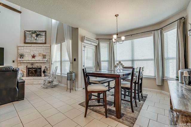 dining room with light tile patterned floors, a stone fireplace, a textured ceiling, a wall mounted air conditioner, and baseboards