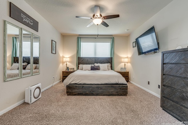 carpeted bedroom with a ceiling fan, a textured ceiling, and baseboards