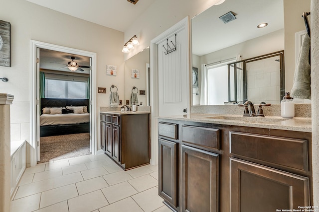 ensuite bathroom featuring ensuite bathroom, a sink, two vanities, visible vents, and a shower stall