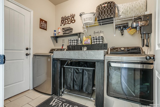 clothes washing area with laundry area, light tile patterned floors, and washer and dryer