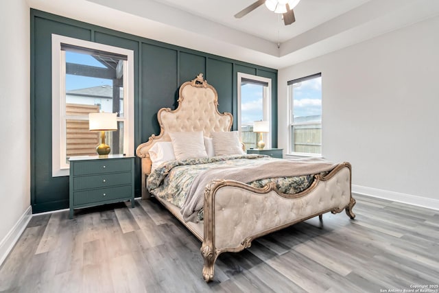 bedroom with ceiling fan, baseboards, and wood finished floors