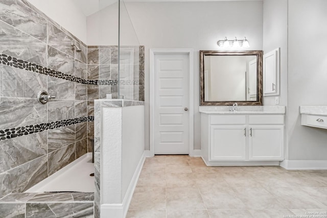 bathroom featuring baseboards, a walk in shower, and vanity