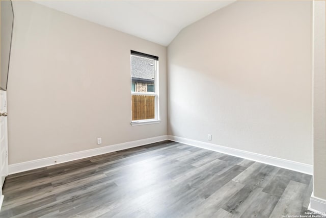 unfurnished room with vaulted ceiling, baseboards, and wood finished floors