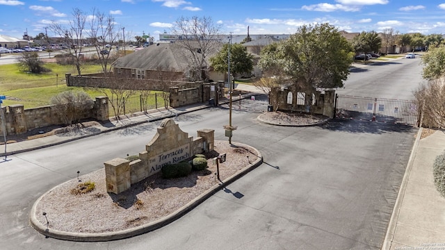 view of street with curbs, a gated entry, a residential view, and a gate