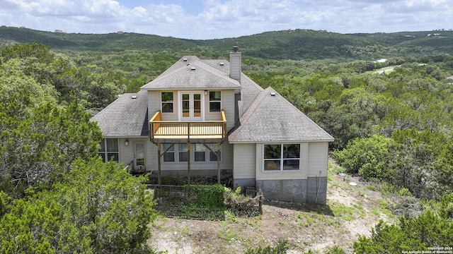 846 County Road 2763, Mico, TX 78056 - rear view of house featuring a shingled roof, a chimney, a view of trees, and french doors