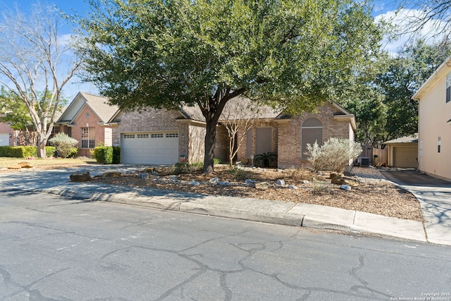 view of front of property featuring a garage, concrete driveway, and brick siding