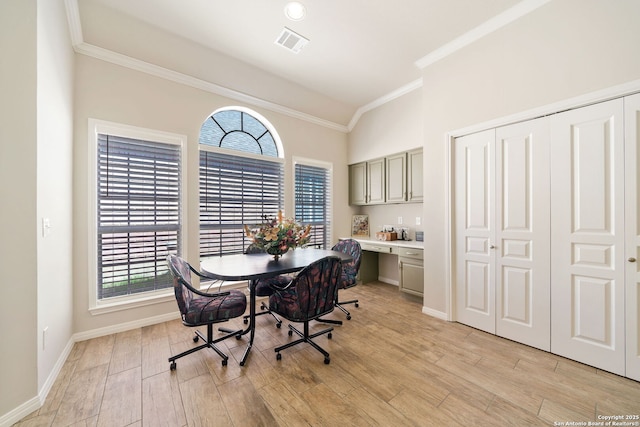 dining space featuring baseboards, visible vents, built in study area, ornamental molding, and light wood-style floors