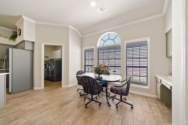 dining room with light wood-style floors, washer and dryer, visible vents, and crown molding