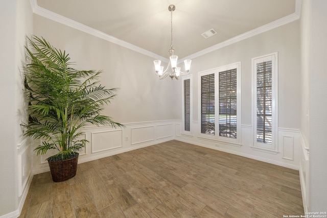 unfurnished dining area featuring ornamental molding, visible vents, and wood finished floors