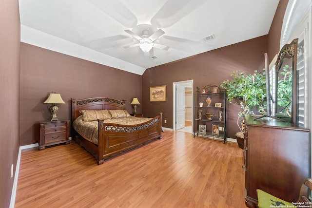 bedroom with baseboards, visible vents, lofted ceiling, ceiling fan, and wood finished floors