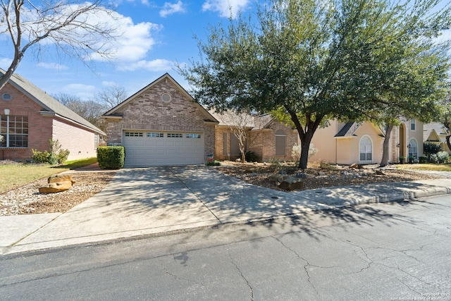 view of front of house with driveway, brick siding, and an attached garage