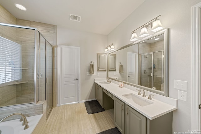 bathroom with a stall shower, visible vents, a sink, and double vanity