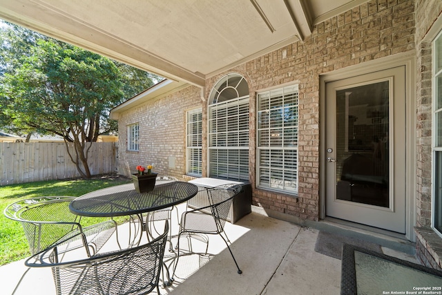 view of patio with outdoor dining space and fence