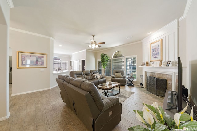 living room with light wood finished floors, crown molding, and a tile fireplace