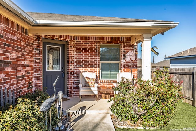 property entrance with fence and brick siding