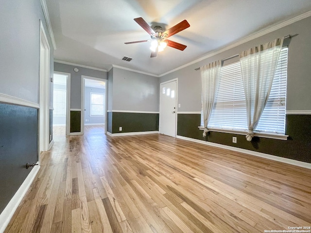 unfurnished living room with baseboards, ornamental molding, visible vents, and light wood-style floors