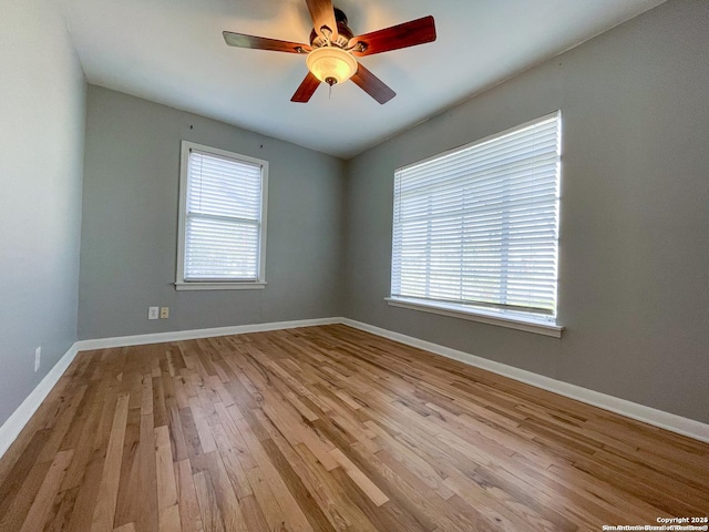 spare room with ceiling fan, wood finished floors, and baseboards