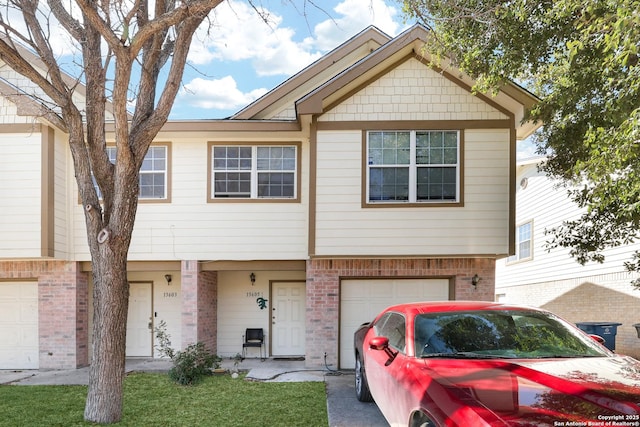 townhome / multi-family property featuring a garage and brick siding