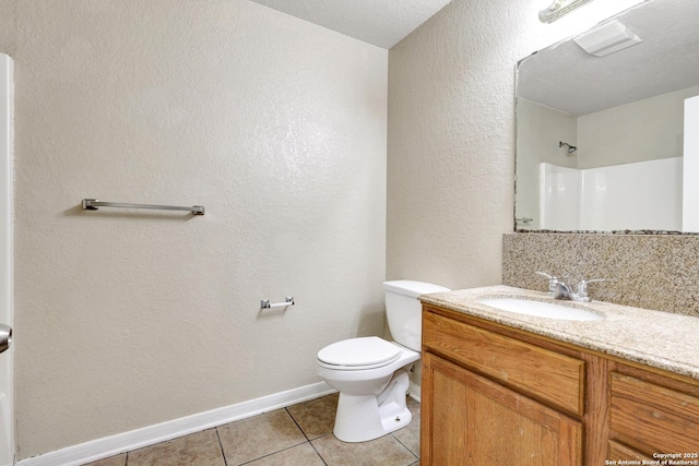 full bathroom featuring a shower, toilet, vanity, tile patterned flooring, and baseboards