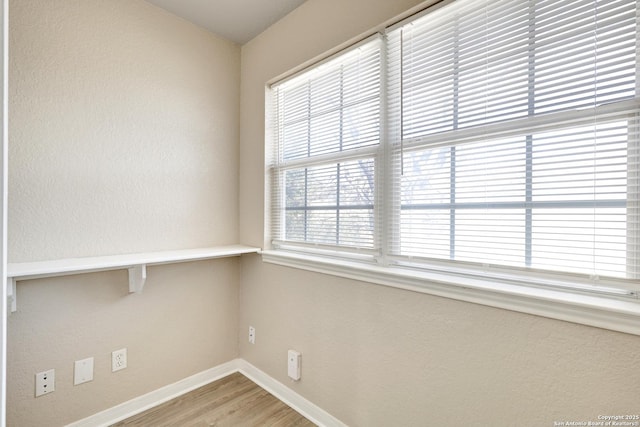 empty room with baseboards and wood finished floors