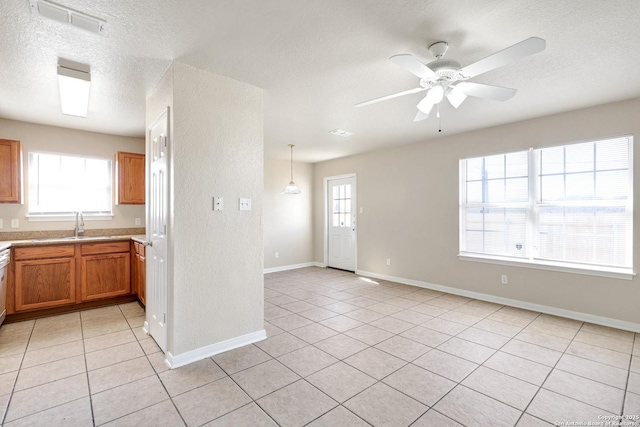 kitchen featuring visible vents, brown cabinetry, light countertops, and light tile patterned flooring