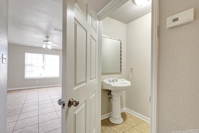 bathroom featuring baseboards, visible vents, ceiling fan, tile patterned floors, and a textured ceiling