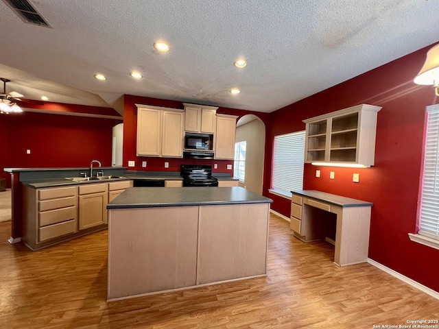 kitchen featuring arched walkways, dark countertops, black appliances, open shelves, and a sink