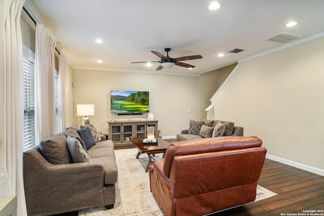 living area featuring dark wood-style floors, visible vents, crown molding, and baseboards