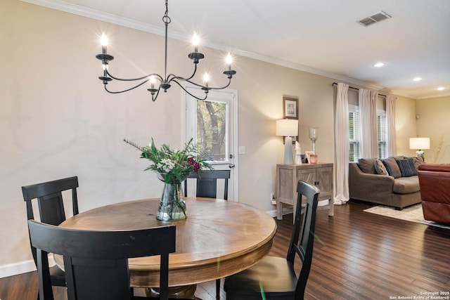 dining area with dark wood-type flooring, a healthy amount of sunlight, visible vents, and ornamental molding