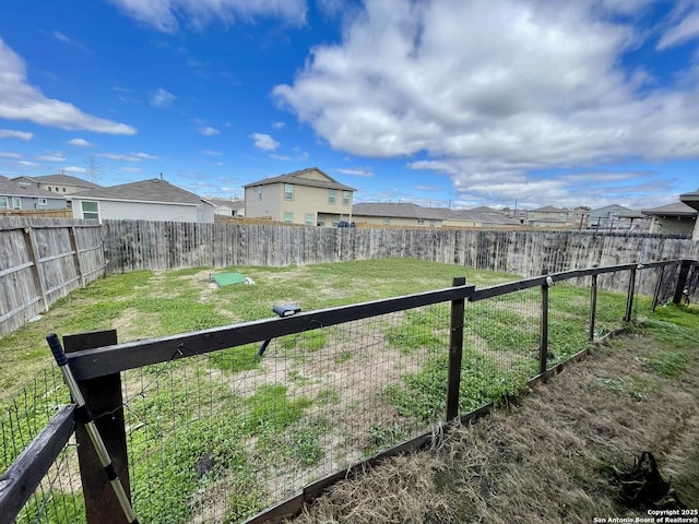 view of yard with a fenced backyard and a residential view