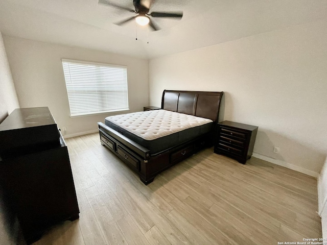 bedroom with light wood finished floors, ceiling fan, and baseboards