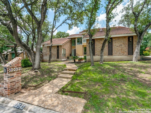 view of front of home with a front lawn and brick siding