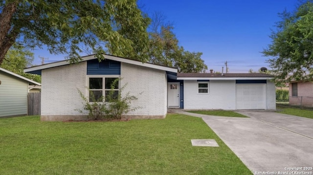 mid-century home with driveway, a front lawn, an attached garage, and brick siding