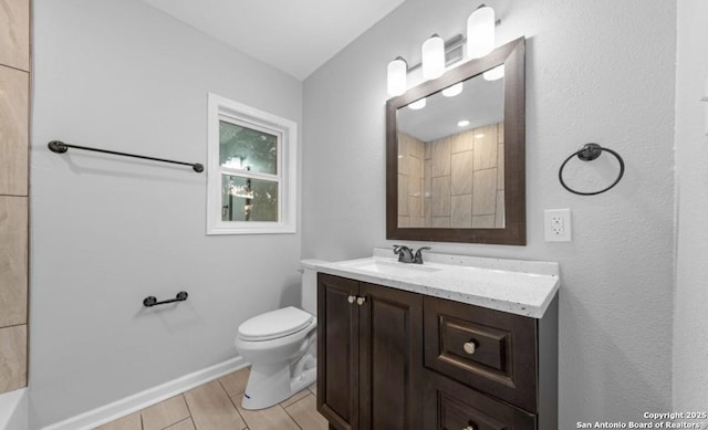 bathroom with a shower, vanity, toilet, and baseboards