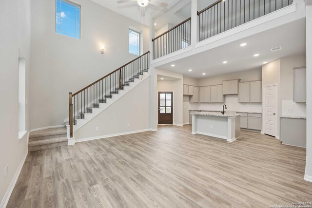 15046 Homing Mdw, San Antonio, TX 78253 - unfurnished living room featuring stairway, light wood-style flooring, baseboards, and a ceiling fan