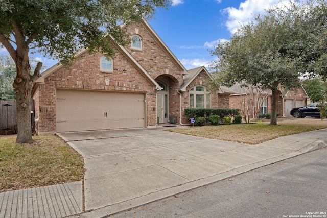 traditional home featuring driveway, a front yard, and brick siding