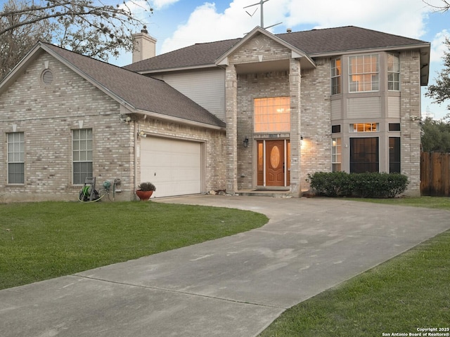 traditional-style home featuring a garage, driveway, a chimney, a front yard, and brick siding