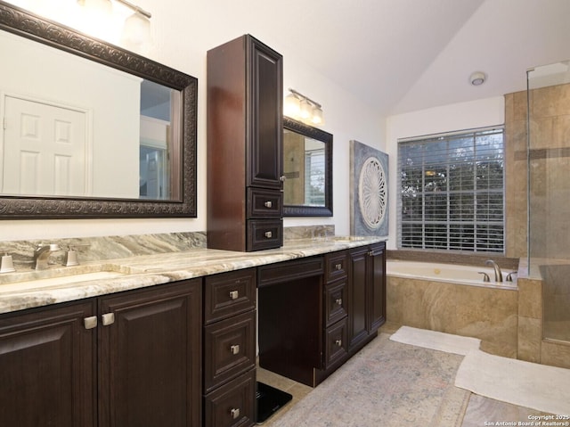 bathroom with double vanity, tile patterned floors, a garden tub, vaulted ceiling, and a sink