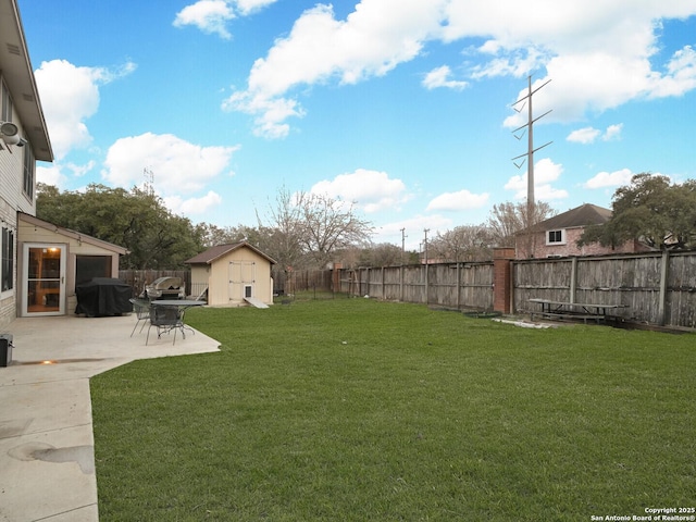 view of yard with a storage shed, a fenced backyard, a patio, and an outdoor structure