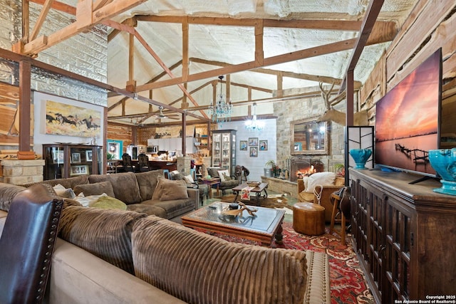 living area with high vaulted ceiling, beam ceiling, and a stone fireplace