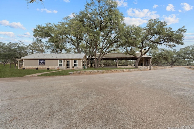 single story home featuring a front lawn and metal roof