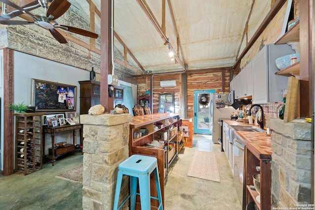 kitchen featuring lofted ceiling, open shelves, unfinished concrete flooring, and wood counters