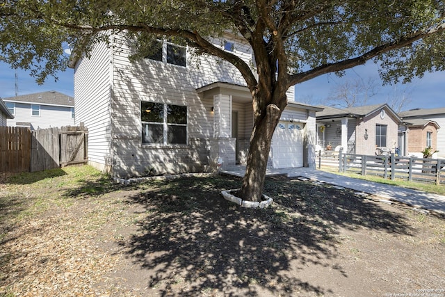 view of front of house featuring an attached garage, driveway, and fence