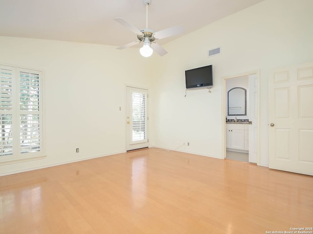 spare room featuring high vaulted ceiling, wood finished floors, visible vents, baseboards, and a ceiling fan