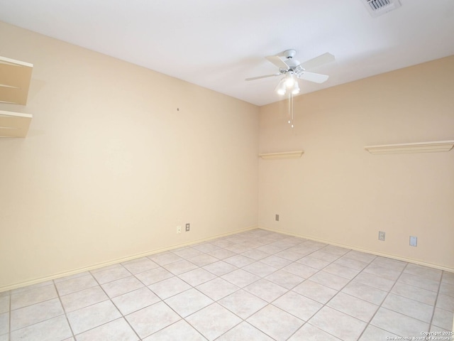 spare room with visible vents, ceiling fan, and baseboards