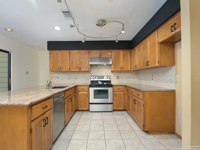 kitchen featuring visible vents, appliances with stainless steel finishes, a peninsula, under cabinet range hood, and a sink