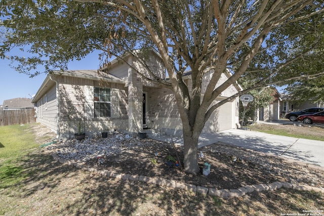 view of front of house featuring a garage, concrete driveway, a front yard, and fence