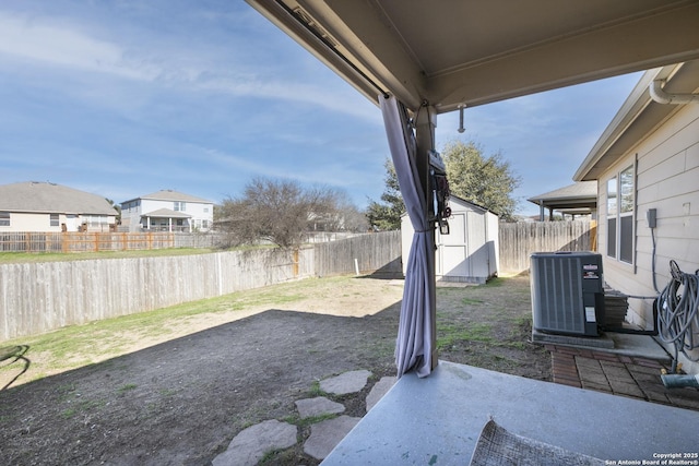 view of yard with an outbuilding, a patio, a storage unit, central air condition unit, and a fenced backyard